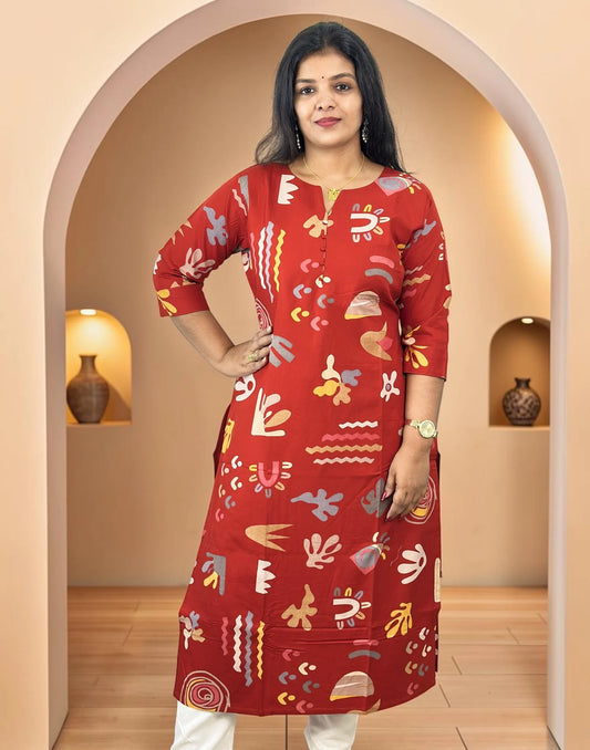 A woman modeling a red three-quarter sleeve kurta with a colorful abstract print, standing in front of a beige arched doorway.